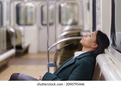 Exhausted american business woman relaxing resting on seat in subway train, returning home after hard working day, sad female office worker in metro underground feels tired after workday