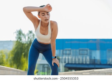 Exhausted athletic runner woman looks at smart watch device fitness bracelet checking time heart rate, pulse, SPO2 after jogging. Tired young female working out cardio outside in sunny urban city park - Powered by Shutterstock