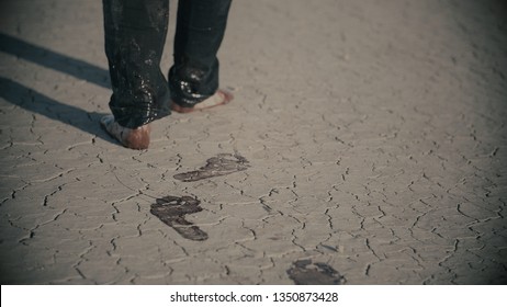 Exhausted Barefoot Man Walking In Desert And Making Bloody Footsteps Before Falling In The End. Blood Stains, Bloody Footprints, Desert Foot Prints. Thriller In 4k With Cold Color Correction.