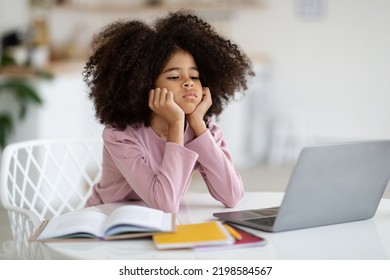 Exhausted Black School Girl Suffering While Doing Homework, Tired From Studying At Home, Getting Ready Before Exams, Stressed With Difficult Task, Using Laptop. Home Education, Homeschooling Concept