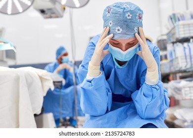 Exhausted and burned out doctor or nurse after an operation in the intensive care unit - Powered by Shutterstock