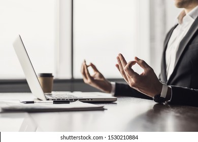 Exhausted businessman meditating in office. Tired men relaxing and doing yoga during work. Male hands in mudra close up view. Business, resting, relaxation, success, balance, concept