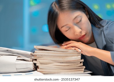 Exhausted businesswoman sleeping on folders in a dimly lit office, conveying burnout and stress in the workplace - Powered by Shutterstock