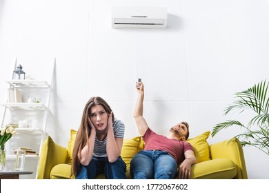 Exhausted Couple Sitting Home With Broken Air Conditioner