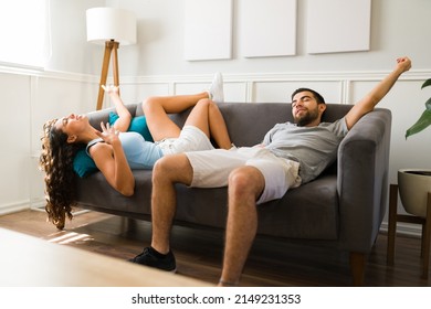 Exhausted couple suffering from heat stroke while resting together on the couch during a hot summer