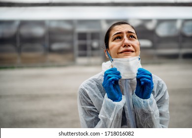 Exhausted Crying Doctor/nurse In Coronavirus Protective Gear N95 Mask.Covid-19 Pandemic Outbreak.Fatalities Grief.Frontline Worker Mental Stress,burnout.Face Mask Scars.Overworked Healthcare Provider