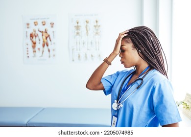 Exhausted Depressed Young Female Doctor Feels Mental Burnout At Work. Stressed Frustrated Physician Upset About Medical Failure, Healthcare Negligence, Having Headache Sits Alone At Desk In Hospital.