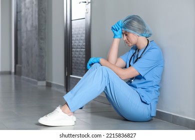 Exhausted Doctor Sitting On Floor In Hospital