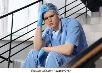 Exhausted doctor sitting on stairs in hospital - Powered by Shutterstock