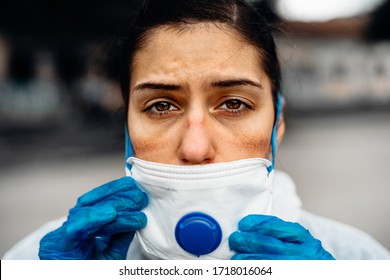 Exhausted doctor/nurse wearing coronavirus protective gear N95 mask uniform.Coronavirus Covid-19 outbreak.Mental stress of frontline worker.Face scars.Mask shortage.Overworked healthcare professional - Shutterstock ID 1718016064
