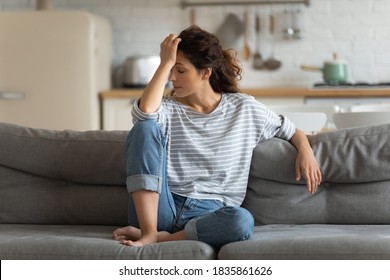 Exhausted Frustrated Young Woman Touching Forehead, Sitting On Couch Alone, Suffering From Strong Headache Or Migraine, Worried Girl Thinking About Problems, Divorce Or Break Up, Lost In Thoughts