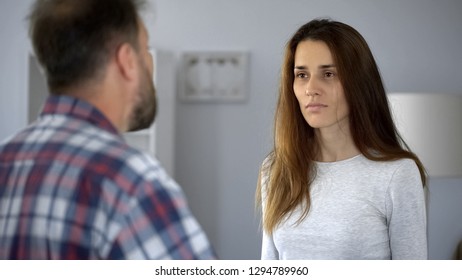 Exhausted lady suffering from domestic violence, arguing with aggressive husband - Shutterstock ID 1294789960