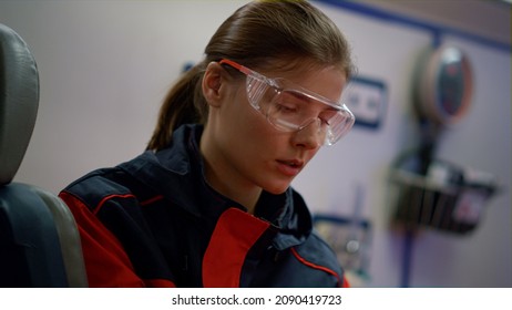 Exhausted Medical Worker Sitting In Ambulance Car After Hard Night Shift. Portrait Female Paramedic With Serious Face Expression. Closeup Ambulance Doctor Looking Away In Protective Glasses 