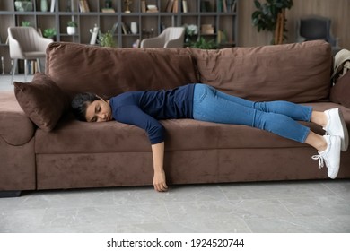 Exhausted millennial Indian woman lying on sofa in living room sleep or take nap. Tired young mixed race ethnicity female renter doze off fall asleep on couch at home. Tiredness, fatigue concept. - Powered by Shutterstock