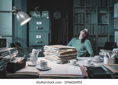 Exhausted office worker falling asleep in the office late at night after drinking too much coffee - Shutterstock ID 1936026901