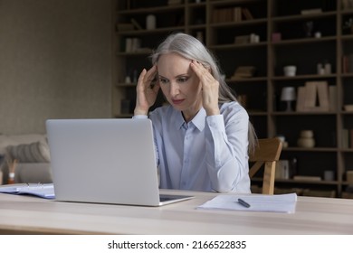 Exhausted Older Businesswoman Sit At Desk With Laptop, Touch Temples Suffer From Headache, Deep In Thoughts, Search Solution, Thinks. Information Overload, Tech Overuse, Hard Stressful Workday Concept