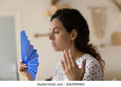 Exhausted Overheated Sweaty Woman Suffering From Heat At Home Without Conditioner, Trying To Cool Too Hot Air With Handheld Fan In Summer Day, Feeling Unwell Du To Weather, Humidity, Air Temperature