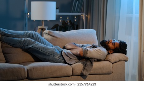 Exhausted Overloaded Arabian Man Indian Bearded Guy Unmotivated Tired Male Came Home After Work Flopped Down On Couch At Night Evening Dark Feels Overworked Sick Ill Person Hard Day No Lack Of Energy