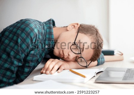 Exhausted school boy sleeping while studying, home interior, copy space