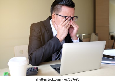 Exhausted Tired Businessman Working On Laptop At Office, Massaging Nose Bridge, Holding Glasses, Feeling Fatigue Discomfort, Eye Strain After Long Wearing Spectacles, Eyesight Problem, Need Eye Drops