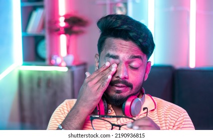 Exhausted Or Tired Gamer Rubbing His Eyes While Playing Video Game During Late Night - Concept Of Gaming Addiction, Health Care And .