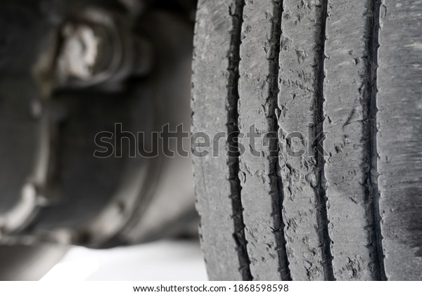Exhausted\
truck tread old damaged and worn black tire tread. Change time.\
Tire tread problems and solutions concept\
