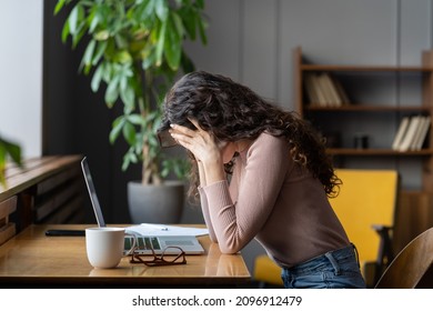 Exhausted upset woman sit at desk hide face in hands tired of difficult tasks. Stressed frustrated female employee feel headache work overtime suffer from burnout at workplace. Stressed businesswoman - Powered by Shutterstock