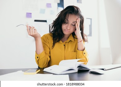 Exhausted white woman having headache at office. Pretty woman in yellow blouse holding glasses in hand, thouching her head and resting with closed eyes. Office worker freelancer. - Shutterstock ID 1818988034