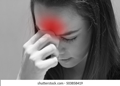 exhausted woman with headache, migraine, stress, hangover, mental problem under day time strong sunlight condition, hand holding forehead between eyebrow