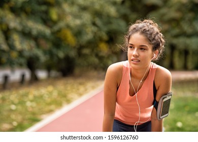 Exhausted Woman Running With Mobile Phone On Her Arm Resting And Looking Away, With Copy Space