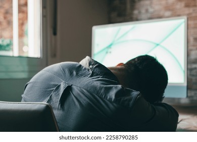 Exhausted young Caucasian male employee sleep desk at office overwork preparing report. Tired male fall asleep doze off at workplace, work late to meet deadline. Fatigue, exhaustion concept.