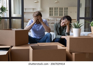 Exhausted young couple sit rest on sofa in living room near heap of cardboard boxes feel unmotivated to unpack their belongings. Financial problem, debt and eviction, hard long relocation day concept - Shutterstock ID 2067029414