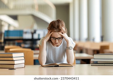 Exhausted young female studying and preparing for exam in college library. Education people concept - Powered by Shutterstock