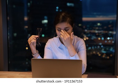 Exhausted young hindu lady take off glasses rub nose feel pain in dry eyes irritated by work before pc screen. Stressed indian woman overworked in office till late night suffer of bad blurry vision - Shutterstock ID 1911367153