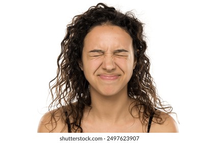 Exhausted young woman  with eyes closed. Pain, stress and despair concept. White studio background - Powered by Shutterstock