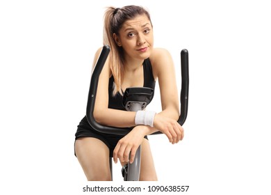 Exhausted Young Woman On An Exercise Bike Isolated On White Background