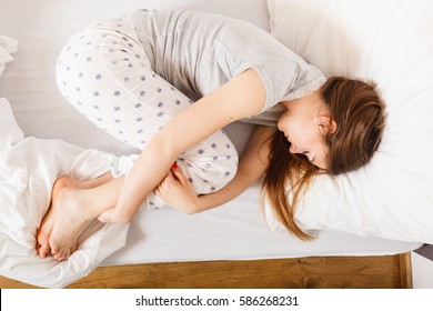 Exhaustion Relax Dreaming Sleep Concept. Tired Girl Sleeping. Young Lady Resting In Fetal Position Recovering In Bed.