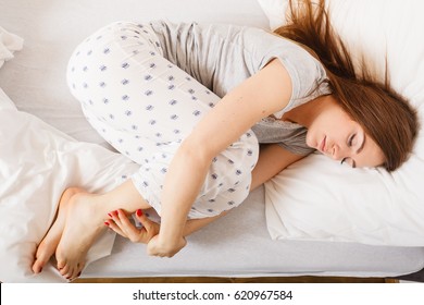 Exhaustion Relax Dreaming Sleep Concept. Tired Girl Sleeping. Young Lady Resting In Fetal Position Recovering In Bed.