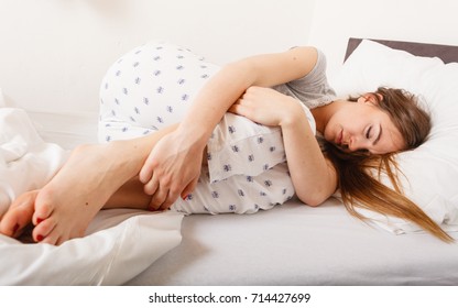 Exhaustion Relax Dreaming Sleep Concept. Tired Girl Sleeping. Young Lady Resting In Fetal Position Recovering In Bed.