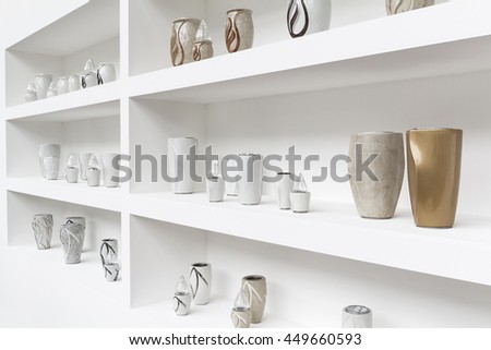 Exhibition of funerary urns, propped on a shelf white.