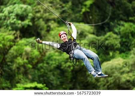 An exhilarating zipline adventure through the lush Ecuadorian rainforest canopy, soaring above the trees on a secure wire for an unforgettable experience.