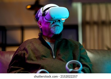 exicet asian senior old man white beard enjoy virtual augmented reality metaverse esport online digital world game in living room at home,casial relax old man play digital leisure game at home  - Powered by Shutterstock