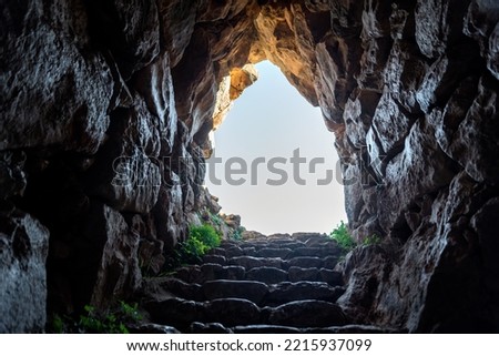 exit from a dark cave with stone steps