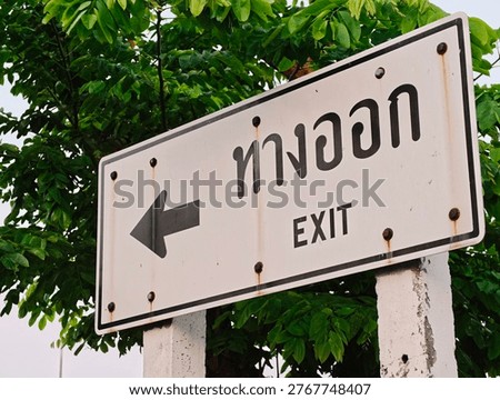 Exit direction sign installed inside parking area guiding drivers toward the exit route for safe vehicle circulation and traffic flow management.