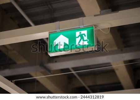 Exit Sign banner with lighting on the wall over walkway in building, Banner Clearly visible emergency exit sign above escape door if has accident