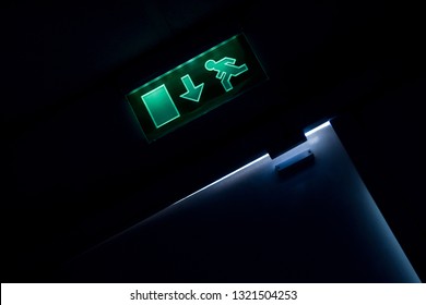 Exit Sign In A Dark Hall Over The Top Of Opened Door