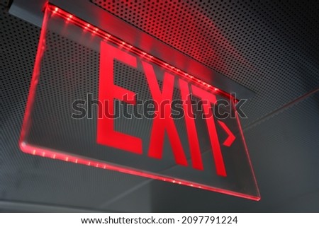 Exit sign. Emergency exit direction indicator on the ceiling in administrative building. Exit warning indicator for public safety in case of emergency like fire alarm to guide to escape or safe haven