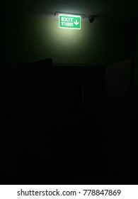 Exit Sign Over Opening Door In The Dark