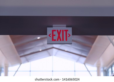 Exit Sign. Red Fire Escape Sign Hang on the Ceiling in the Airport. 
