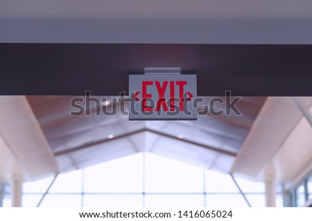 Exit Sign. Red Fire Escape Sign Hang on the Ceiling in the Airport. 
